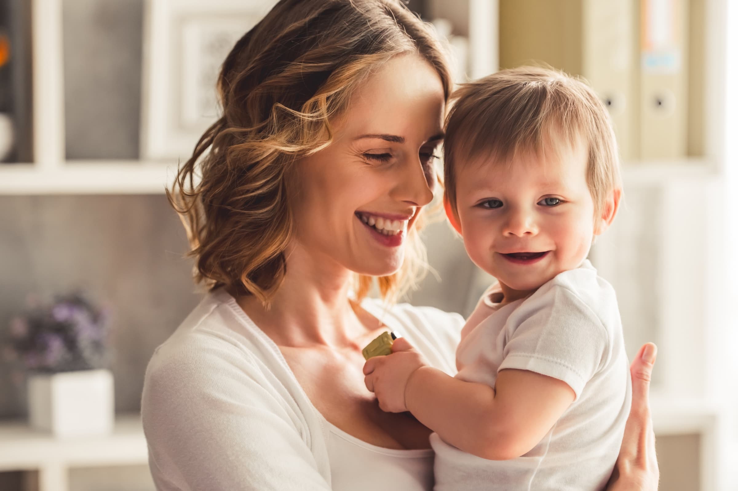 A smiling mother holding her toddler